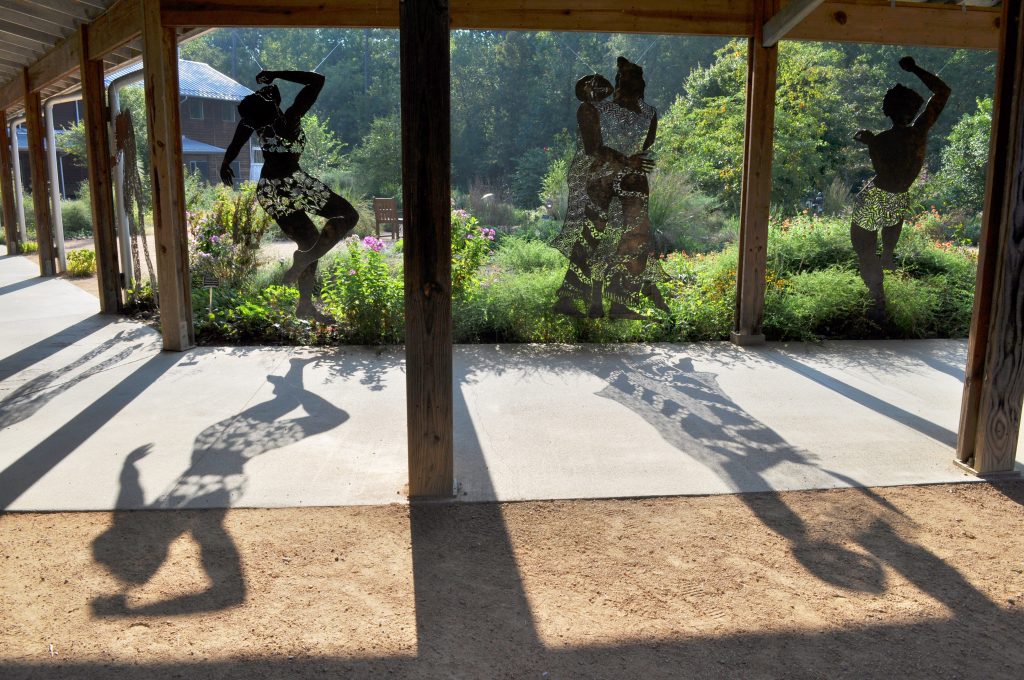 Plasma-cut steel figures hang in a breezeway at the Garden.