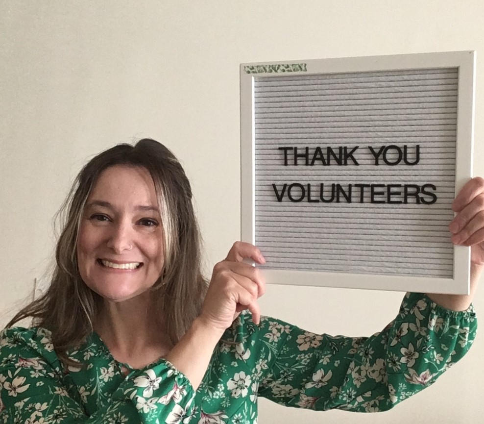 person holding thank you volunteers sign