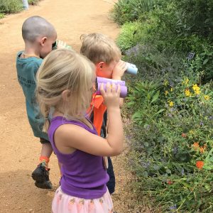 Kids use homemade "binoculars" to look at flowers