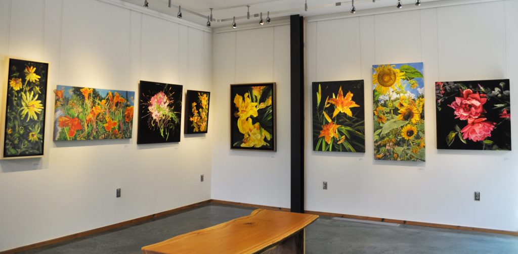 Large botanical oil paintings by Susan Brabeau displayed in the DeBerry Gallery
