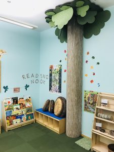 Reading Nook in the Peacock Discovery Room, with children's books and tree cushions